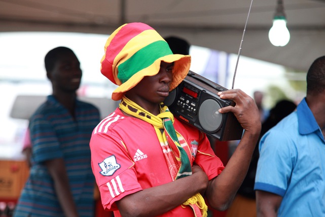Egy ghánai szurkoló rádión hallgatja a válogatott meccs kommentálását, Accrában, 2014 június 26-án.